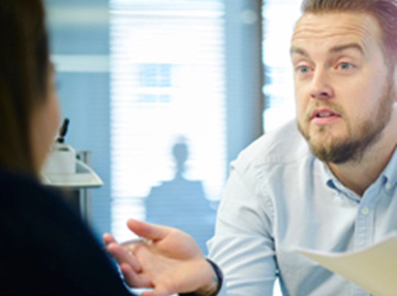 Mann diskuterer med kollega