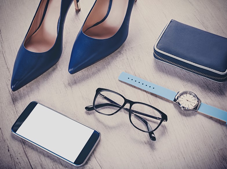 Stillettsko, mobil, briller, klokke og lommebok på gulvet