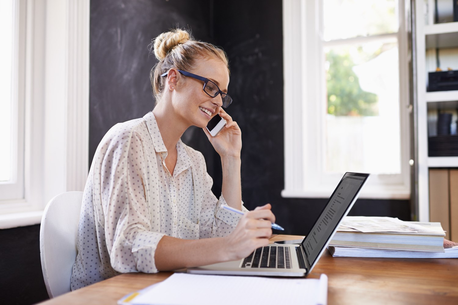 Kvinne i telefon noterer på PC